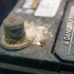 Oxydation sur une cosse de batterie, expliquant pourquoi les cosses de batterie s'oxydent. Danger : gaz explosifs.