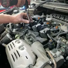 Mécanicien remplaçant une bougie d'allumage pour optimiser la durée de vie de la bougie d'allumage. Moteur de voiture détaillé.