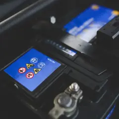 Gros plan sur une batterie de voiture, avec ses symboles de sécurité. Une batterie neuve déchargée, prête à être remplacée.