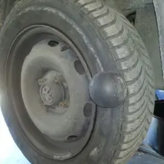 Gros gonflement sur un pneu de voiture, ressemblant à une boule noire.