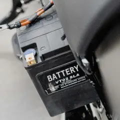 Batterie de moto, peut-être un symptôme de démarreur fatigué. Les câbles sont connectés aux bornes.