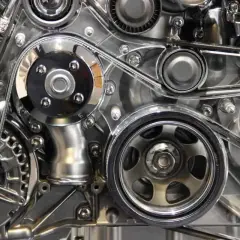 Détail mécanique d'un moteur, avec la courroie de distribution d'un C4 Picasso bien visible, entourée de poulies chromées.