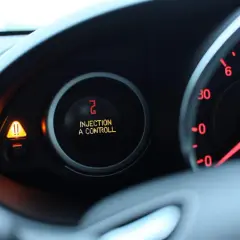 Tableau de bord d'une Clio 3 avec voyant orange "Injection à contrôler" allumé. Panne de l'injection à prévoir.