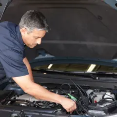 Mécanicien diagnostiquant un démarrage difficile à chaud diesel. Il utilise un appareil de mesure connecté au moteur.