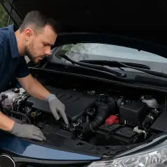 Mécanicien inspectant un moteur. Si votre véhicule a un défaut moteur, faites réparer le véhicule sans perte de puissance.