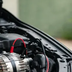 Diagnostic d'un panne alternateur symptôme : un alternateur de voiture avec des câbles de test connectés.