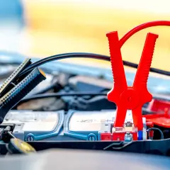 Pinces rouges et noires connectées à la batterie pour démarrer une voiture essence ou diesel.