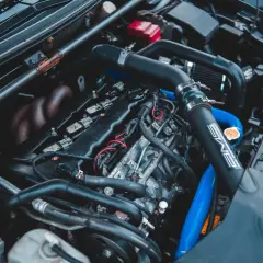 Moteur de voiture avec durites bleues et noires. On peut tester l'actuateur de ralenti sur ce moteur.