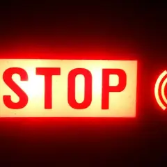 Voyant rouge "STOP" allumé, avec le symbole du frein à main activé.