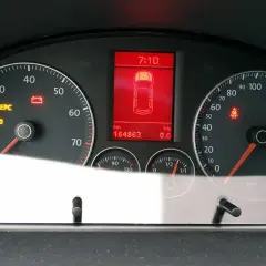 Tableau de bord d'une voiture avec voyant EPC allumé, témoin de batterie et de ceinture de sécurité. Kilométrage : 164863 km.