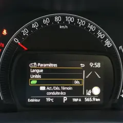 Tableau de bord Toyota Aygo X : voyant pression pneu allumé, menu paramètres affiché. Vitesse 0 km/h, température extérieure 19°C.