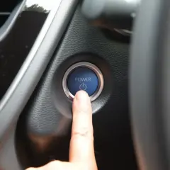 Doigt sur le bouton "POWER" de la voiture, le moteur ne démarre pas. Un vrai problème démarreur voiture.