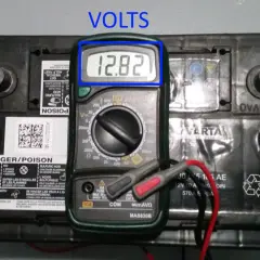 Comment tester une batterie : un multimètre affiche 12,82 V sur une batterie de voiture Varta.