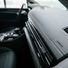 Vue intérieure d'un Peugeot Expert. Le tableau de bord en cuir noir avec surpiqûres blanches et l'inscription "AIRBAG" sont visibles. L'emplacement du calculateur airbag est ici.