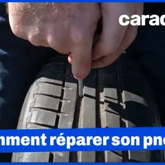 Un homme utilise un outil pour insérer une mèche dans un pneu. La réparation pneu mèche est interdite sur le flanc.