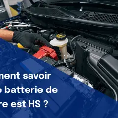 Main d'un mécanicien travaillant sur le compartiment moteur d'une voiture, vérifiant la batterie. Le texte indique "Comment savoir si une batterie de voiture est HS ?".