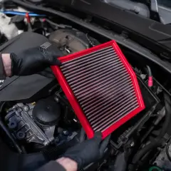 Maintenant, je vais nettoyer le filtre à air de la voiture. Il est rouge et rectangulaire.