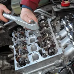 Mécanicien serrant des boulons sur un moteur. Rouler avec un joint de culasse défectueux est impossible.