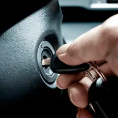 Une main insère une clé dans le Neiman. La question "peut on mettre du dégrippant dans un neiman" reste en suspens.