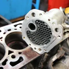 Refroidisseur EGR démonté, prêt pour réparation. Un symptôme refroidisseur EGR HS peut causer des problèmes de performance moteur.