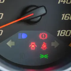 Tableau de bord avec voyant rouge de pression pneu allumé, signalant un problème.