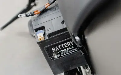 Batterie de moto, peut-être un symptôme de démarreur fatigué. Les câbles sont connectés aux bornes.