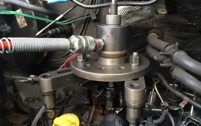 Outil pour comment enlever un injecteur grippé sans extracteur. Le dispositif est fixé sur le moteur, prêt à extraire l'injecteur récalcitrant.