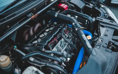 Moteur de voiture avec durites bleues et noires. On peut tester l'actuateur de ralenti sur ce moteur.