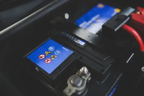 Gros plan sur une batterie de voiture, avec ses symboles de sécurité. Une batterie neuve déchargée, prête à être remplacée.