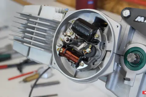 Mécanisme interne d'un moteur, montrant les bobines et les contacts pour le réglage de l'avance à l'allumage.