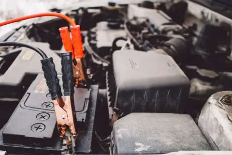 Pinces de démarrage connectées à une batterie de voiture. Une solution pour comment recharger une batterie de voiture sans rien.