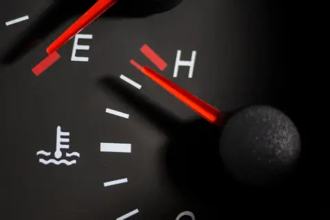 Indicateur de température du liquide de refroidissement du moteur. Le logo du thermomètre est visible, la jauge est proche de "H" (chaud).