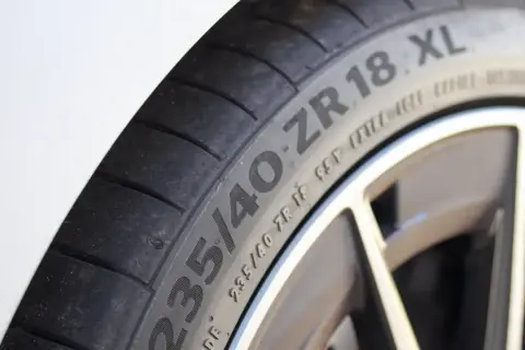 Gros plan sur un pneu de voiture avec l'inscription "235/40 ZR 18 XL". Le "XL" indique une capacité de charge accrue, ce qui répond à la question "pneu XL c'est quoi".