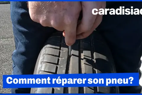 Un homme utilise un outil pour insérer une mèche dans un pneu. La réparation pneu mèche est interdite sur le flanc.