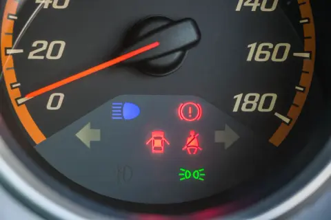 Tableau de bord avec voyant rouge de pression pneu allumé, signalant un problème.