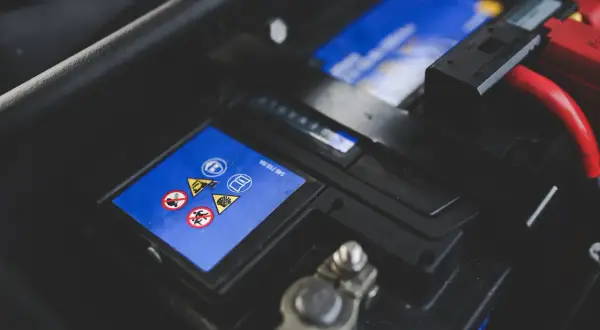 Gros plan sur une batterie de voiture, avec ses symboles de sécurité. Une batterie neuve déchargée, prête à être remplacée.