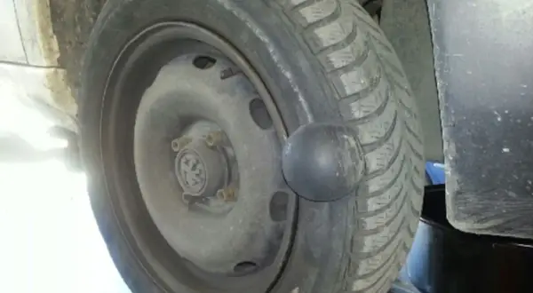 Gros gonflement sur un pneu de voiture, ressemblant à une boule noire.