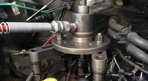 Outil pour comment enlever un injecteur grippé sans extracteur. Le dispositif est fixé sur le moteur, prêt à extraire l'injecteur récalcitrant.