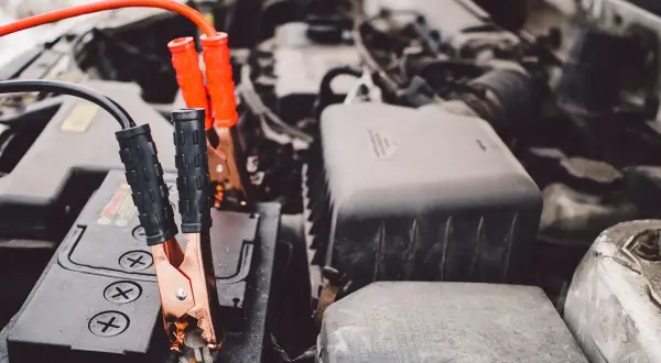 Pinces de démarrage connectées à une batterie de voiture. Une solution pour comment recharger une batterie de voiture sans rien.