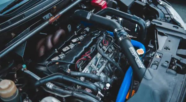 Moteur de voiture avec durites bleues et noires. On peut tester l'actuateur de ralenti sur ce moteur.