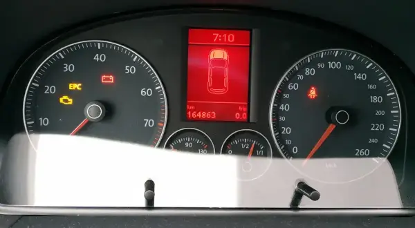 Tableau de bord d'une voiture avec voyant EPC allumé, témoin de batterie et de ceinture de sécurité. Kilométrage : 164863 km.