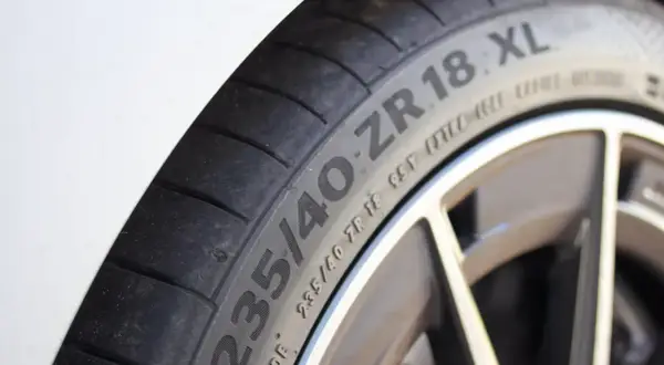 Gros plan sur un pneu de voiture avec l'inscription "235/40 ZR 18 XL". Le "XL" indique une capacité de charge accrue, ce qui répond à la question "pneu XL c'est quoi".