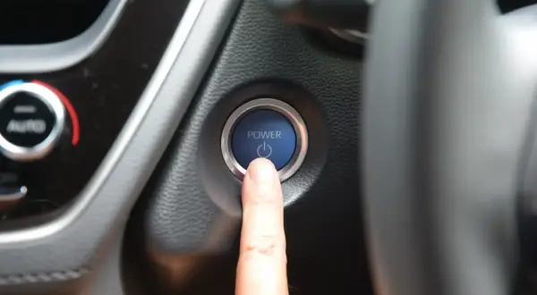 Doigt sur le bouton "POWER" de la voiture, le moteur ne démarre pas. Un vrai problème démarreur voiture.