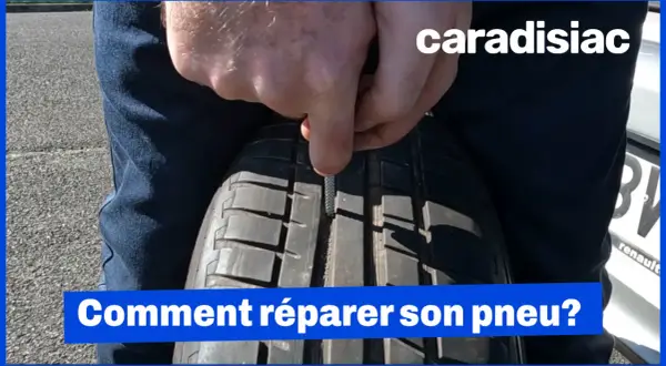 Un homme utilise un outil pour insérer une mèche dans un pneu. La réparation pneu mèche est interdite sur le flanc.