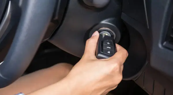 Main tenant insère la clé dans le contact, espérant que la voiture qui ne démarre pas finira par démarrer.