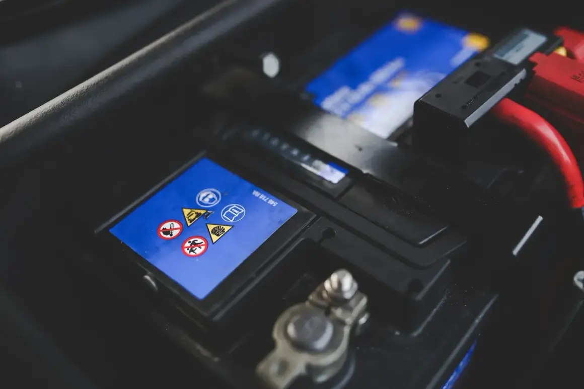 Gros plan sur une batterie de voiture, avec ses symboles de sécurité. Une batterie neuve déchargée, prête à être remplacée.