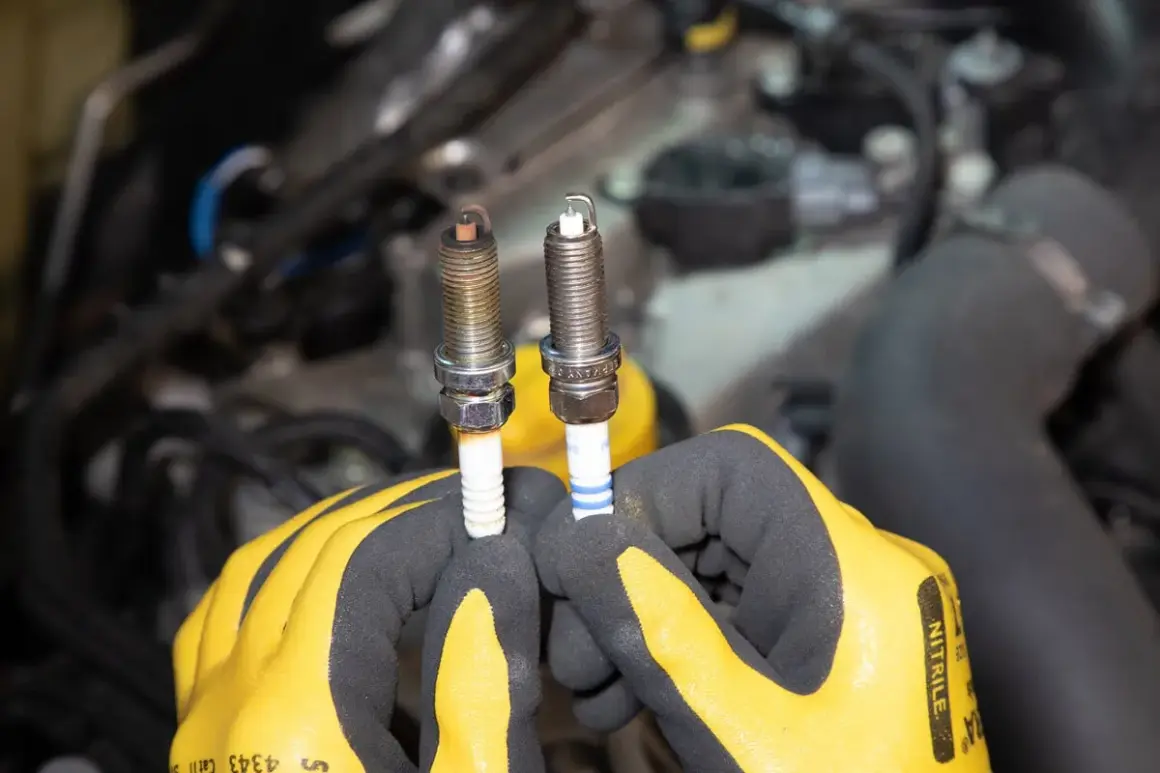 Gants jaunes tenant deux bougies d'allumage essence, l'une usée, l'autre neuve. Il est temps de savoir quand changer les bougies d'allumage essence.