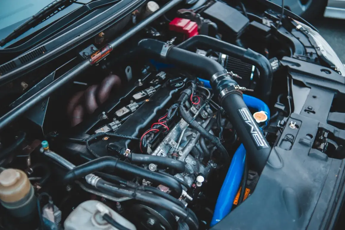 Moteur de voiture avec durites bleues et noires. On peut tester l'actuateur de ralenti sur ce moteur.