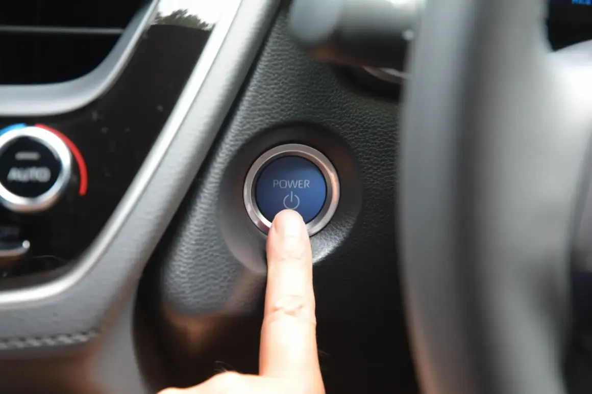 Doigt sur le bouton "POWER" de la voiture, le moteur ne démarre pas. Un vrai problème démarreur voiture.