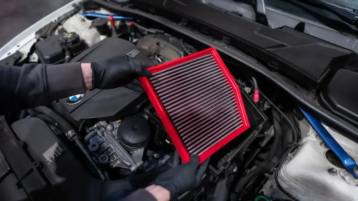 Maintenant, je vais nettoyer le filtre à air de la voiture. Il est rouge et rectangulaire.